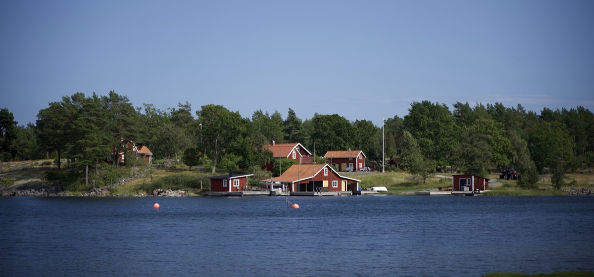 Röda sjöbodar och bryggor på en klippig ö i Östergötlands skärgård