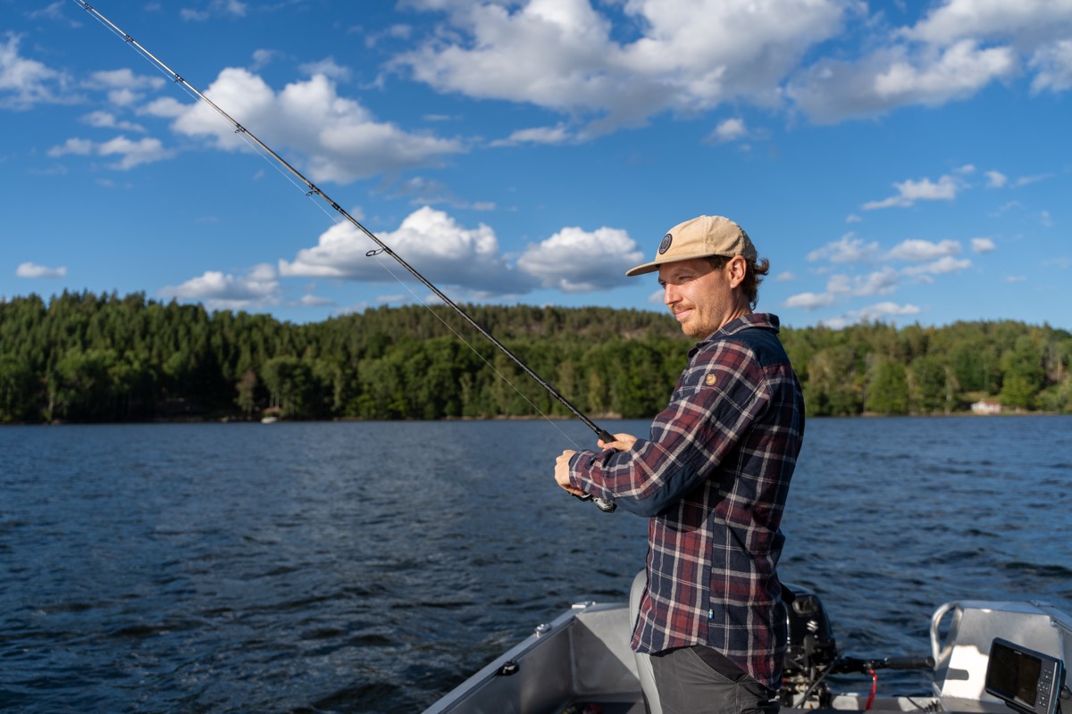 Sportfiskare med böjt spö ombord på fiskebåten