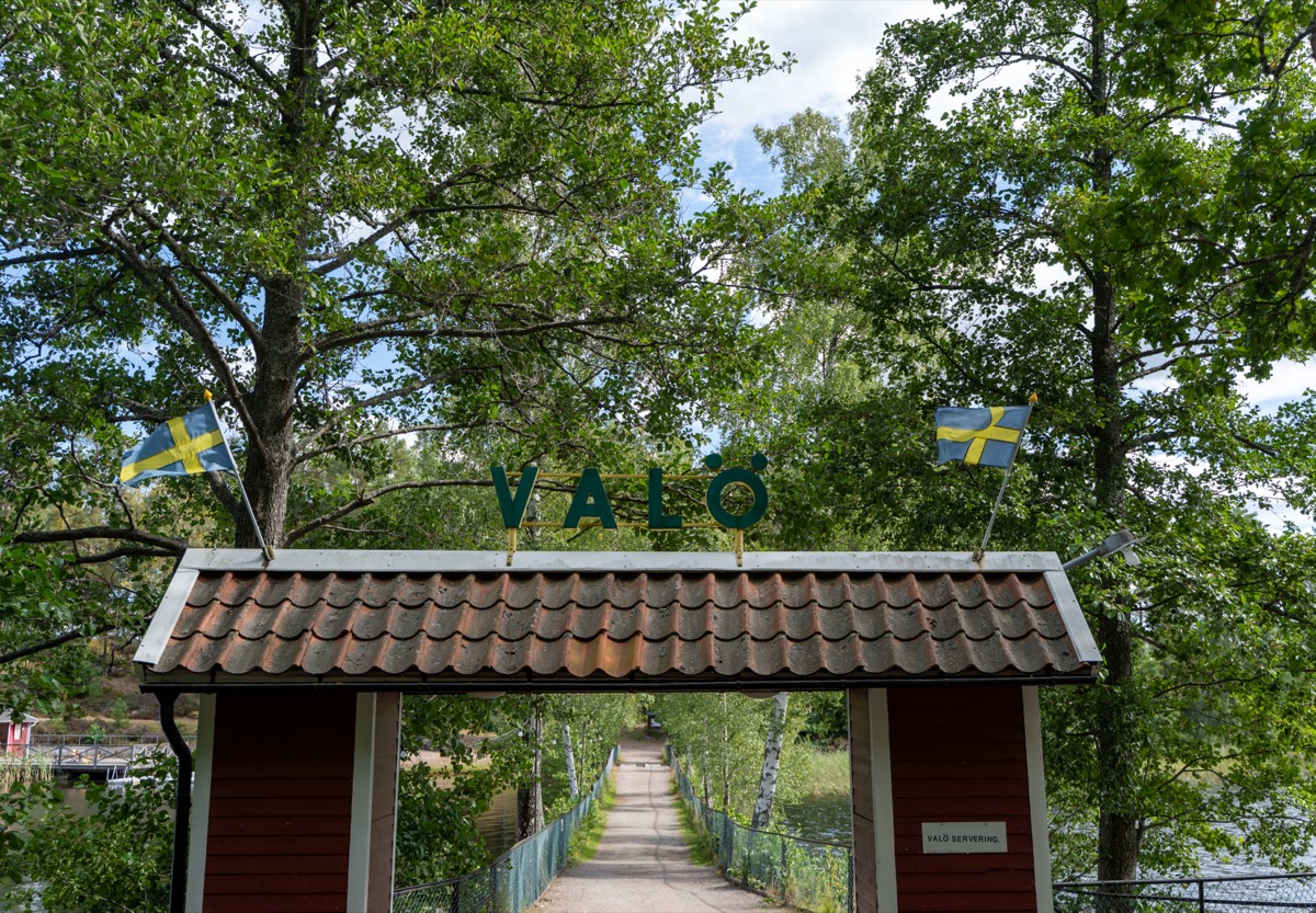 Entréporten till Valö med svenska flaggor och bron bakom